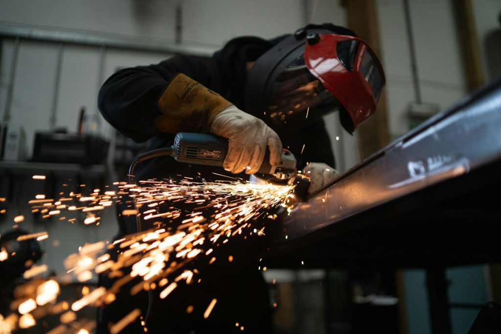 Welder grinding a steel frame